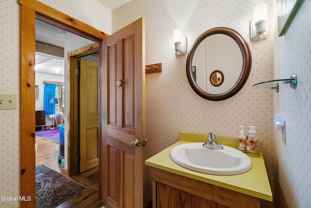 135 Willow St, Guilderland, NY 12084 - bathroom with vanity, wallpapered walls, and wood finished floors
