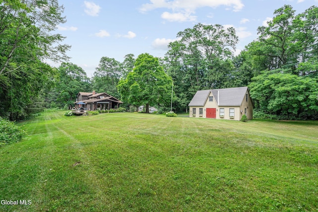 135 Willow St, Guilderland, NY 12084 - view of grassy yard with a detached garage, an outdoor structure, and driveway