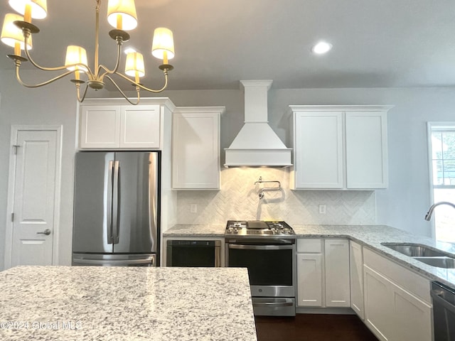 3 Priddle Ln, Colonie, NY 12110 - kitchen with stainless steel appliances, custom exhaust hood, white cabinets, backsplash, and a chandelier