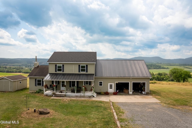 367 Buel Rd, Canajoharie, NY 13317 - view of front facade with a porch, gravel driveway, a front yard, a metal roof, and a storage unit
