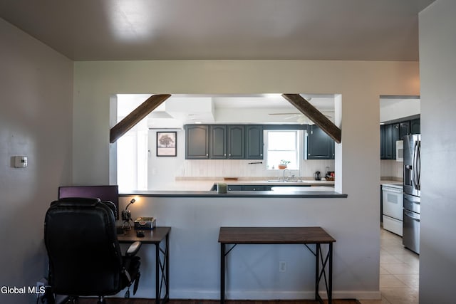 367 Buel Rd, Canajoharie, NY 13317 - kitchen with white appliances, a kitchen bar, a peninsula, light tile patterned flooring, and light countertops