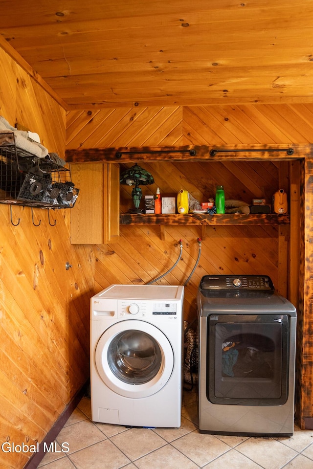 367 Buel Rd, Canajoharie, NY 13317 - laundry area featuring washer and clothes dryer, light tile patterned flooring, and wood walls
