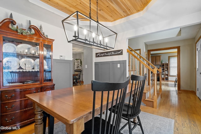 125 Halfmoon Dr, Guilderland, NY 12009 - dining space with wood ceiling, a raised ceiling, stairway, light wood-style flooring, and a chandelier