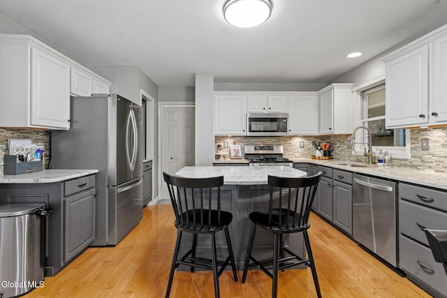 125 Halfmoon Dr, Guilderland, NY 12009 - kitchen featuring gray cabinets, appliances with stainless steel finishes, white cabinetry, tasteful backsplash, and a center island