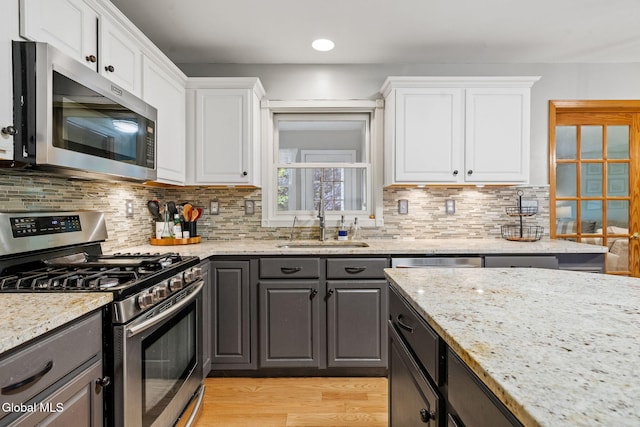 125 Halfmoon Dr, Guilderland, NY 12009 - kitchen with stainless steel appliances, white cabinets, tasteful backsplash, light stone counters, and recessed lighting