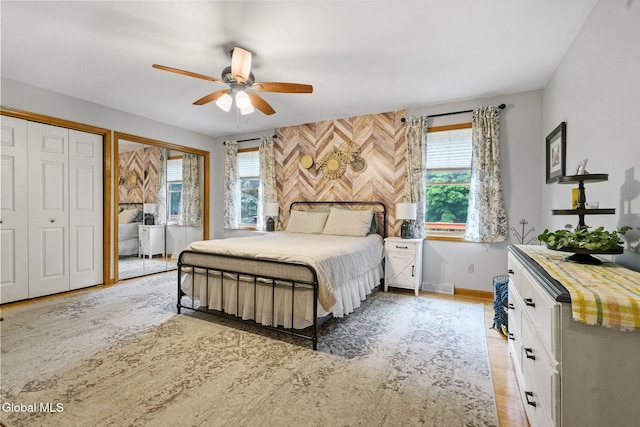 125 Halfmoon Dr, Guilderland, NY 12009 - bedroom with multiple windows, light wood-type flooring, a ceiling fan, and multiple closets