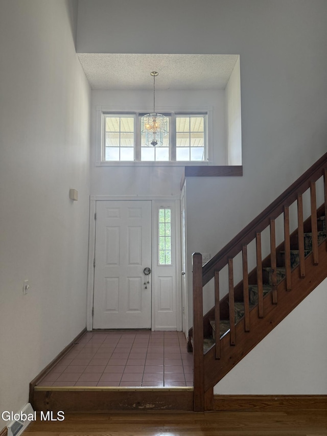 5 Crowsnest Ct, Halfmoon, NY 12188 - foyer with stairway, a chandelier, tile patterned flooring, and a textured ceiling