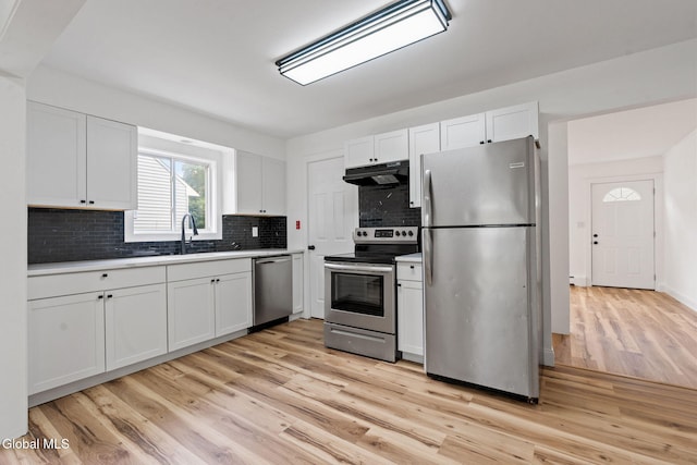 10 Perry Ave, Colonie, NY 12110 - kitchen with stainless steel appliances, under cabinet range hood, white cabinets, backsplash, and light wood-style flooring