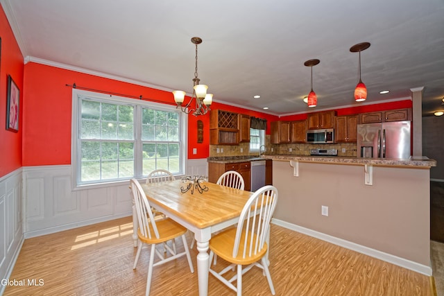 50 Sandy Ln, Bethlehem, NY 12158 - dining space with light wood-style floors, a chandelier, a wainscoted wall, and crown molding