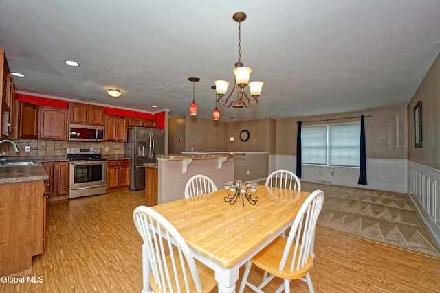 50 Sandy Ln, Bethlehem, NY 12158 - dining space with light wood-type flooring, a chandelier, and a wainscoted wall