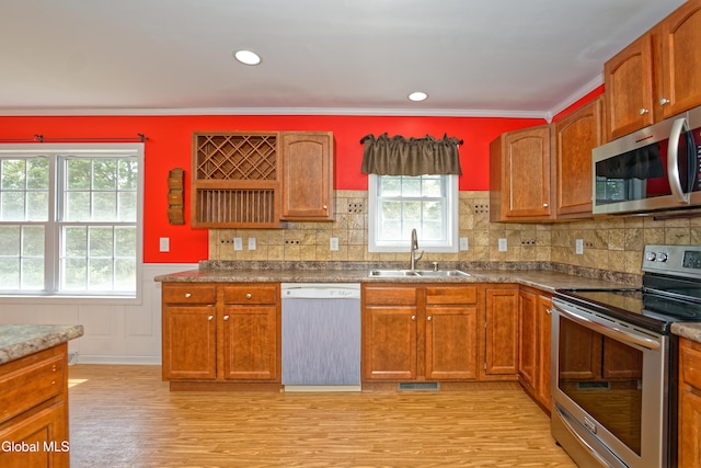 50 Sandy Ln, Bethlehem, NY 12158 - kitchen with stainless steel appliances, healthy amount of natural light, light wood-style flooring, wainscoting, and brown cabinetry