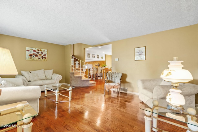 145 Sylvia Ln, Rotterdam, NY 12306 - living area featuring stairs, a textured ceiling, and wood finished floors
