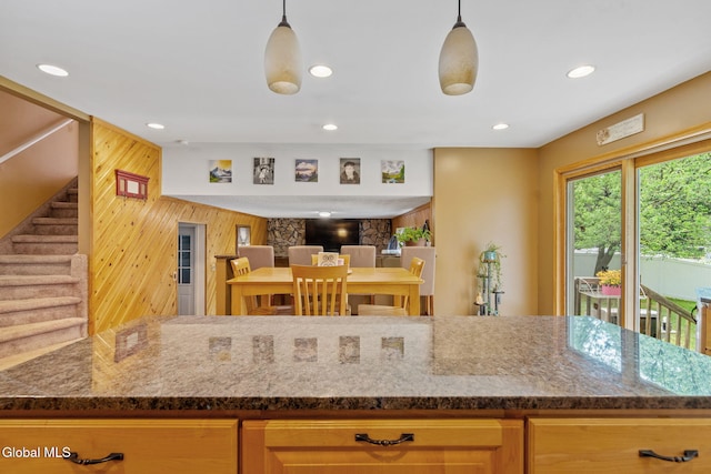 145 Sylvia Ln, Rotterdam, NY 12306 - kitchen featuring wood walls, dark stone countertops, recessed lighting, and hanging light fixtures