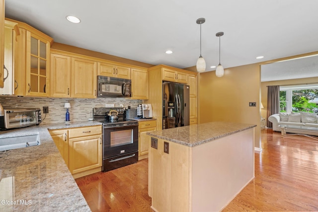 145 Sylvia Ln, Rotterdam, NY 12306 - kitchen featuring black appliances, light brown cabinetry, a kitchen island, light wood-style flooring, and decorative backsplash