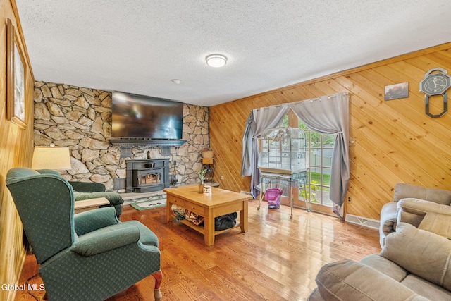 145 Sylvia Ln, Rotterdam, NY 12306 - living area featuring a textured ceiling, wood walls, a wood stove, and wood finished floors