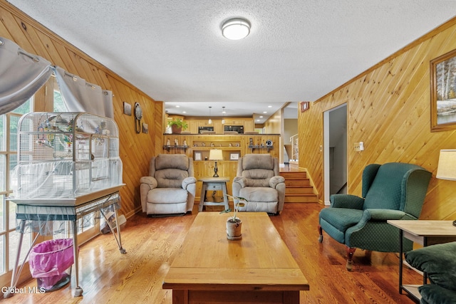 145 Sylvia Ln, Rotterdam, NY 12306 - living area featuring wood walls, a textured ceiling, light wood-type flooring, and stairs