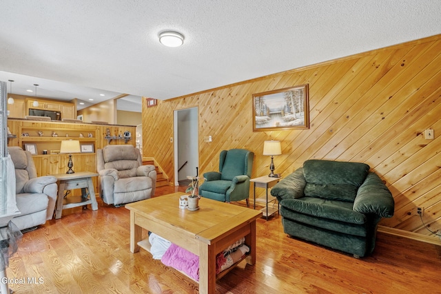 145 Sylvia Ln, Rotterdam, NY 12306 - living area featuring light wood-style flooring, wooden walls, and a textured ceiling