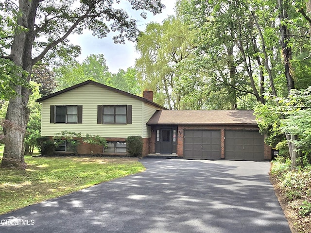 12 Winkel Way, Clifton Park, NY 12019 - tri-level home featuring driveway, an attached garage, a chimney, and brick siding