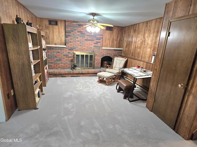 12 Winkel Way, Clifton Park, NY 12019 - carpeted living room featuring a ceiling fan, wood walls, and a brick fireplace