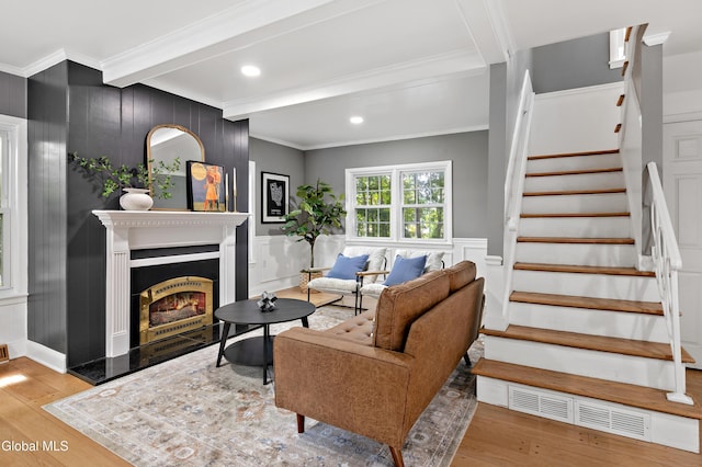 84 Glenwood Ave, Queensbury, NY 12804 - living room featuring beamed ceiling, wood finished floors, stairs, ornamental molding, and a lit fireplace