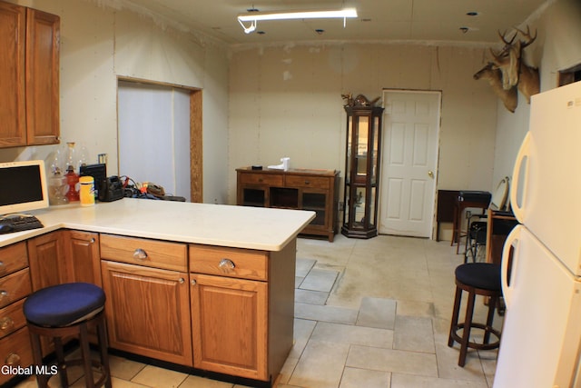 135 Glenwild Rd, Providence, NY 12850 - kitchen featuring freestanding refrigerator, a peninsula, and brown cabinets