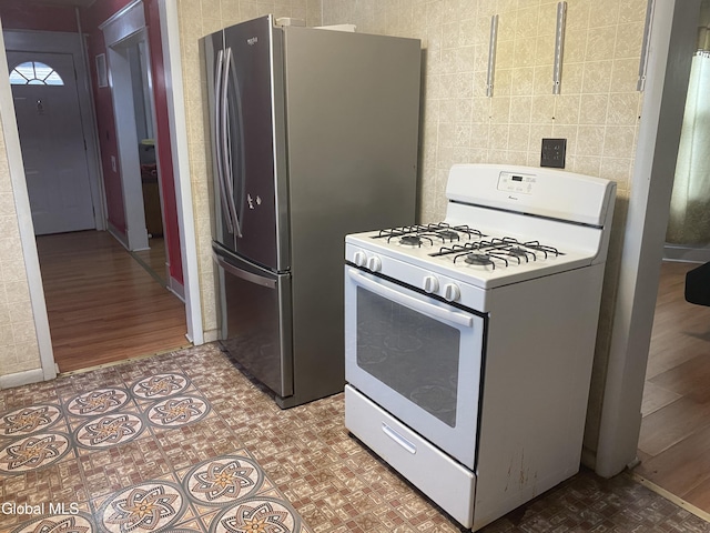 1341 7th Ave, Schenectady, NY 12303 - kitchen with gas range gas stove, freestanding refrigerator, and tile walls
