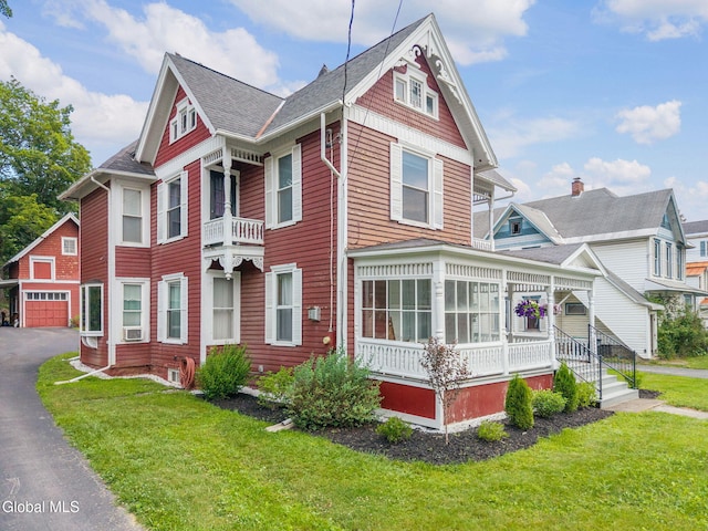 138 Elm St, Cobleskill, NY 12043 - victorian home with an outdoor structure, a front yard, a shingled roof, and cooling unit