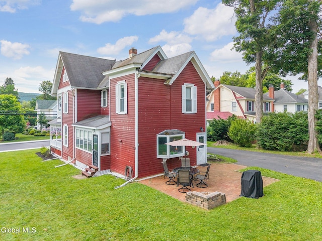 138 Elm St, Cobleskill, NY 12043 - view of home's exterior with entry steps, a chimney, a lawn, and a shingled roof
