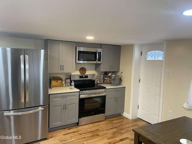 12 Louden Rd, Saratoga Springs, NY 12866 - kitchen with appliances with stainless steel finishes, gray cabinetry, light wood-type flooring, light countertops, and recessed lighting