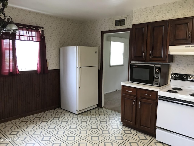23 Cottage Hill Rd, Queensbury, NY 12804 - kitchen with white appliances, under cabinet range hood, wallpapered walls, light countertops, and a wainscoted wall