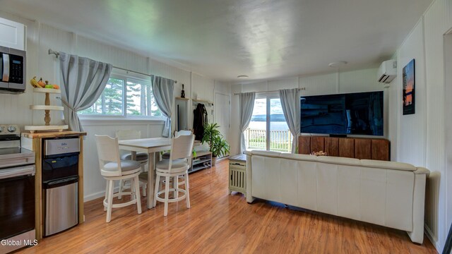 115 Shore Dr, Broadalbin, NY 12025 - living room featuring a wall mounted AC, light wood-style floors, and plenty of natural light