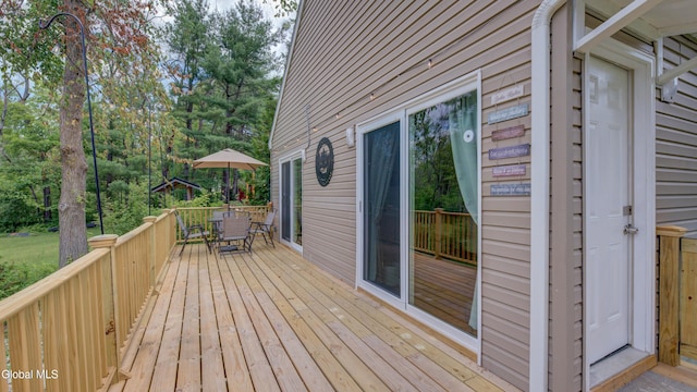 115 Shore Dr, Broadalbin, NY 12025 - wooden terrace with outdoor dining space and view of wooded area