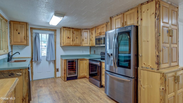 115 Shore Dr, Broadalbin, NY 12025 - kitchen with appliances with stainless steel finishes, wine cooler, light wood-type flooring, light countertops, and light brown cabinets