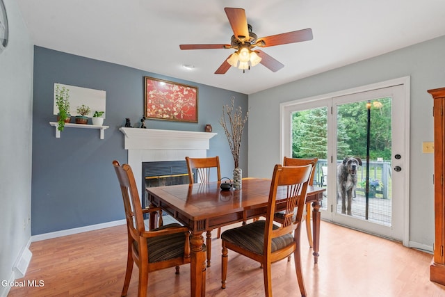 5 Gregg Rd, Altamont, NY 12009 - dining room featuring a tiled fireplace, light wood-style flooring, and ceiling fan