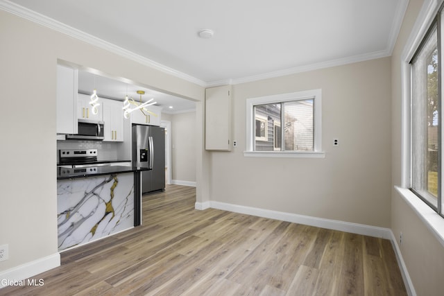 789 Troy Schenectady Rd, Colonie, NY 12110 - kitchen featuring appliances with stainless steel finishes, plenty of natural light, white cabinets, light wood finished floors, and crown molding