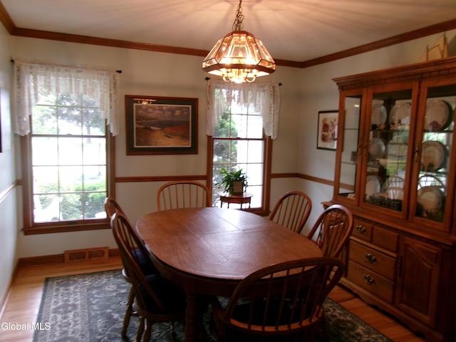 22 Frances Ln, Bethlehem, NY 12203 - dining area with wood finished floors, plenty of natural light, a chandelier, and ornamental molding