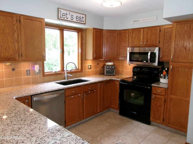 22 Frances Ln, Bethlehem, NY 12203 - kitchen with appliances with stainless steel finishes, brown cabinetry, backsplash, and light stone countertops