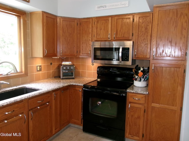 22 Frances Ln, Bethlehem, NY 12203 - kitchen featuring stainless steel microwave, black range with electric stovetop, and brown cabinets
