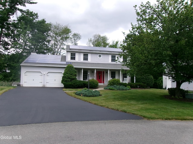 22 Frances Ln, Bethlehem, NY 12203 - view of front facade with an attached garage, covered porch, driveway, solar panels, and a front yard