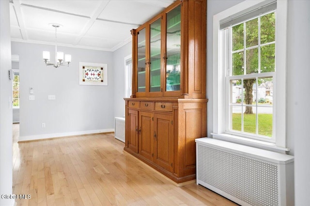 7 Swan St, Hudson Falls, NY 12839 - corridor with radiator, a chandelier, light wood-style flooring, ornamental molding, and coffered ceiling