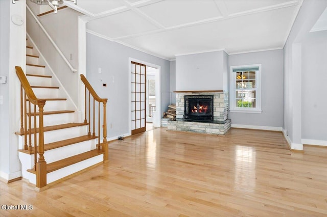 7 Swan St, Hudson Falls, NY 12839 - unfurnished living room with light wood-style flooring, stairway, a stone fireplace, and crown molding