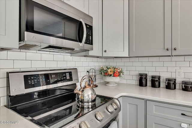 611 Via Ponderosa, Schenectady, NY 12303 - kitchen with stainless steel appliances, decorative backsplash, and light countertops