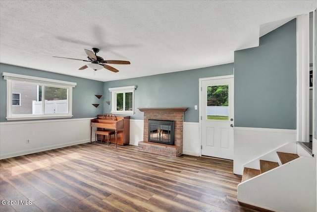 611 Via Ponderosa, Schenectady, NY 12303 - unfurnished living room with a textured ceiling, wood finished floors, a ceiling fan, plenty of natural light, and a fireplace