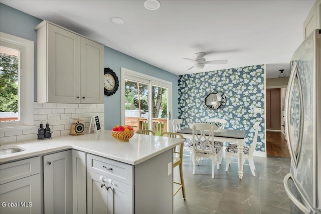 611 Via Ponderosa, Schenectady, NY 12303 - kitchen with freestanding refrigerator, a peninsula, a ceiling fan, light countertops, and wallpapered walls