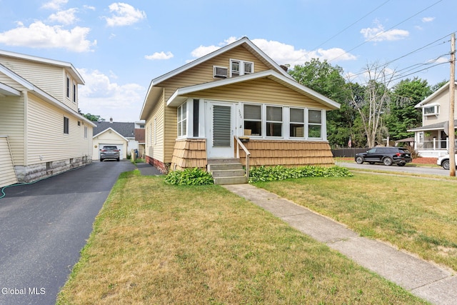 2780 Campbell Ave, Schenectady, NY 12306 - bungalow featuring a detached garage, a front lawn, an outbuilding, and driveway