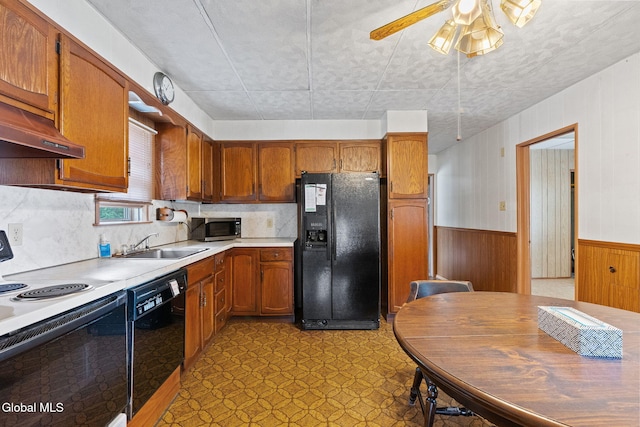 2780 Campbell Ave, Schenectady, NY 12306 - kitchen featuring black appliances, light countertops, brown cabinetry, a wainscoted wall, and wood walls