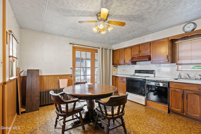 2780 Campbell Ave, Schenectady, NY 12306 - kitchen featuring white range with electric stovetop, black dishwasher, radiator, under cabinet range hood, and light countertops
