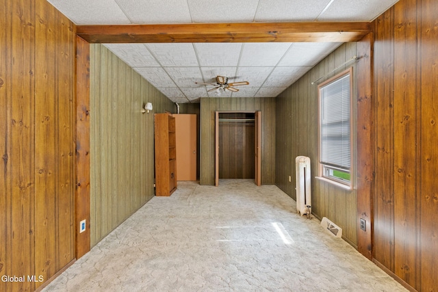 2780 Campbell Ave, Schenectady, NY 12306 - carpeted empty room with radiator heating unit, a ceiling fan, and wood walls