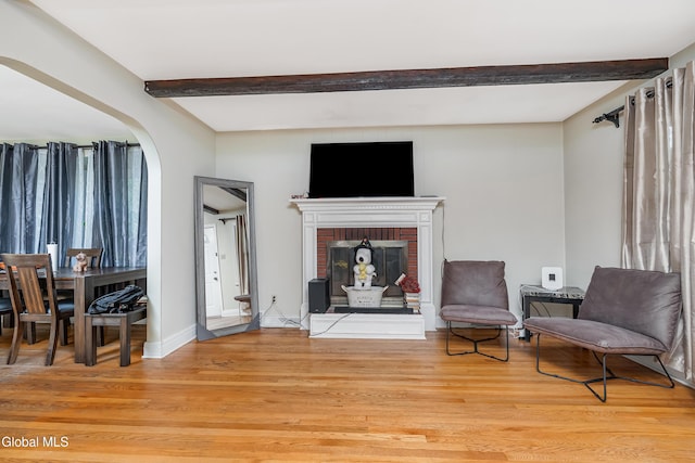 19 Elmhurst Ave, Colonie, NY 12205 - living area featuring beam ceiling, light wood-style flooring, a fireplace, and arched walkways