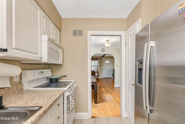 19 Elmhurst Ave, Colonie, NY 12205 - kitchen with white appliances, arched walkways, white cabinets, light countertops, and light tile patterned flooring